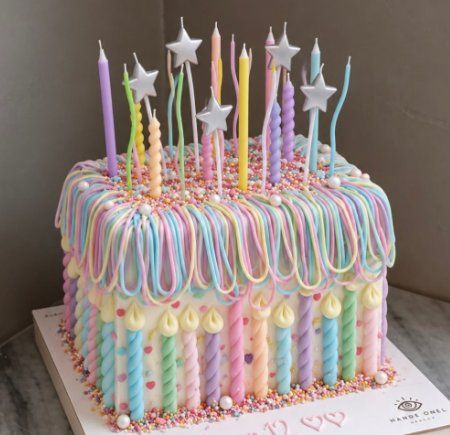 Bolo pastel com velas torcidas e velas de estrela